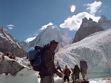 03 Porter Muhammad Khan Crossing A Small River On The Upper Baltoro Glacier With Gasherbrum IV Behind